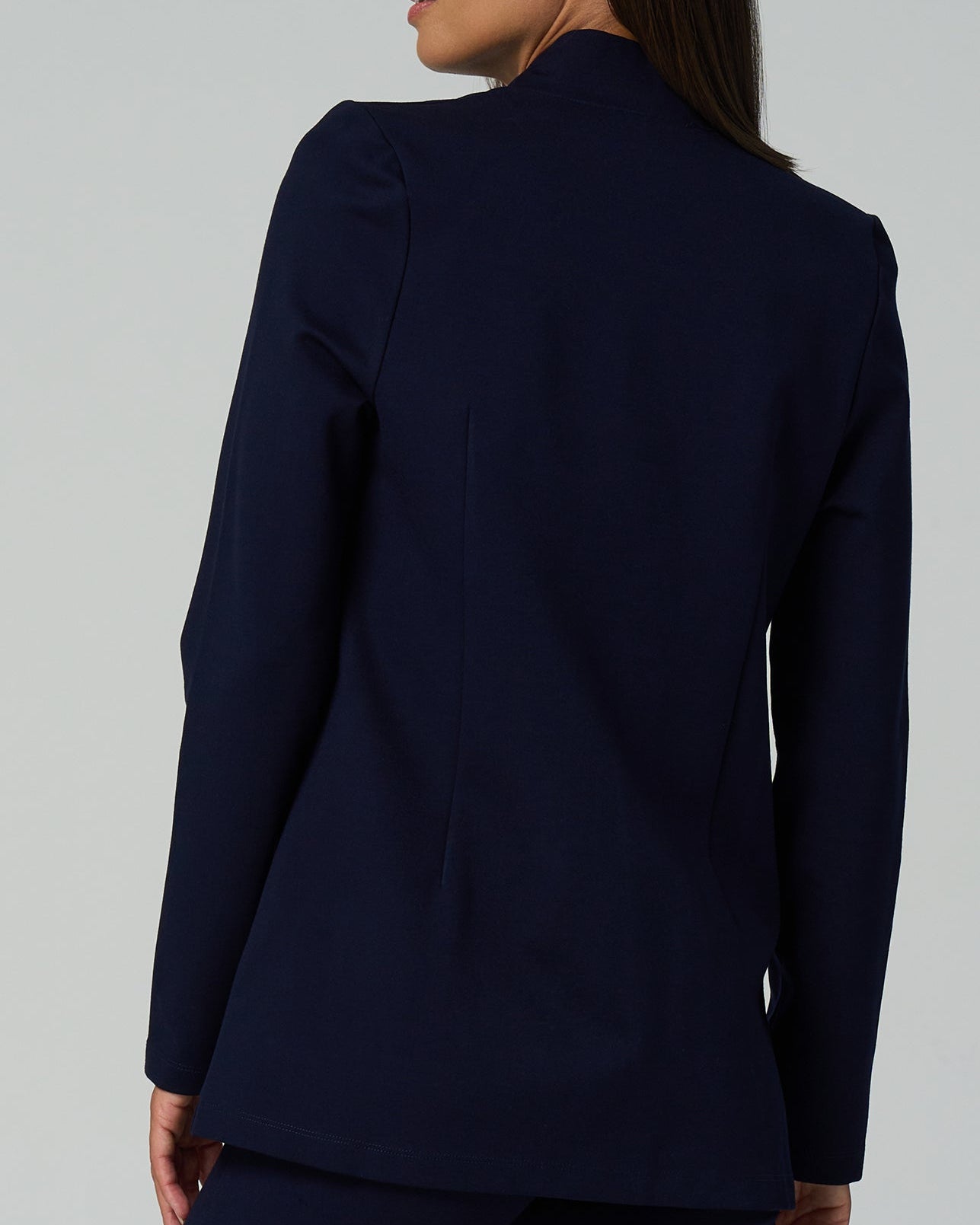 Navy blue suit jacket worn by a person on a light gray background