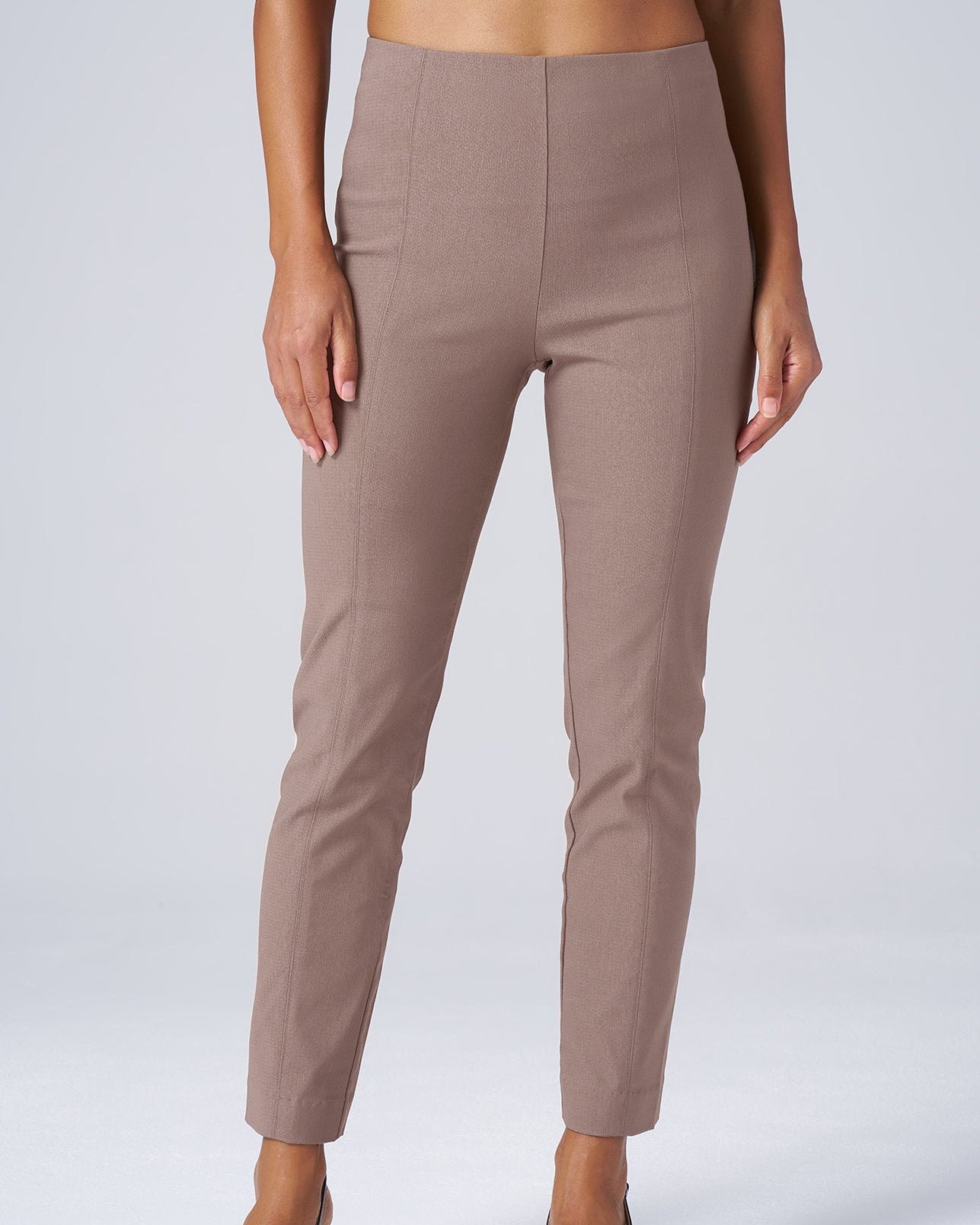 Beige pants worn by a person on a white background