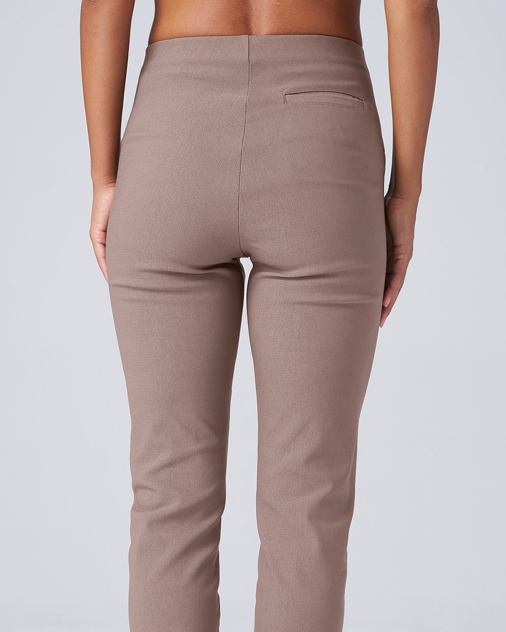 Beige pants worn by a person on a white background