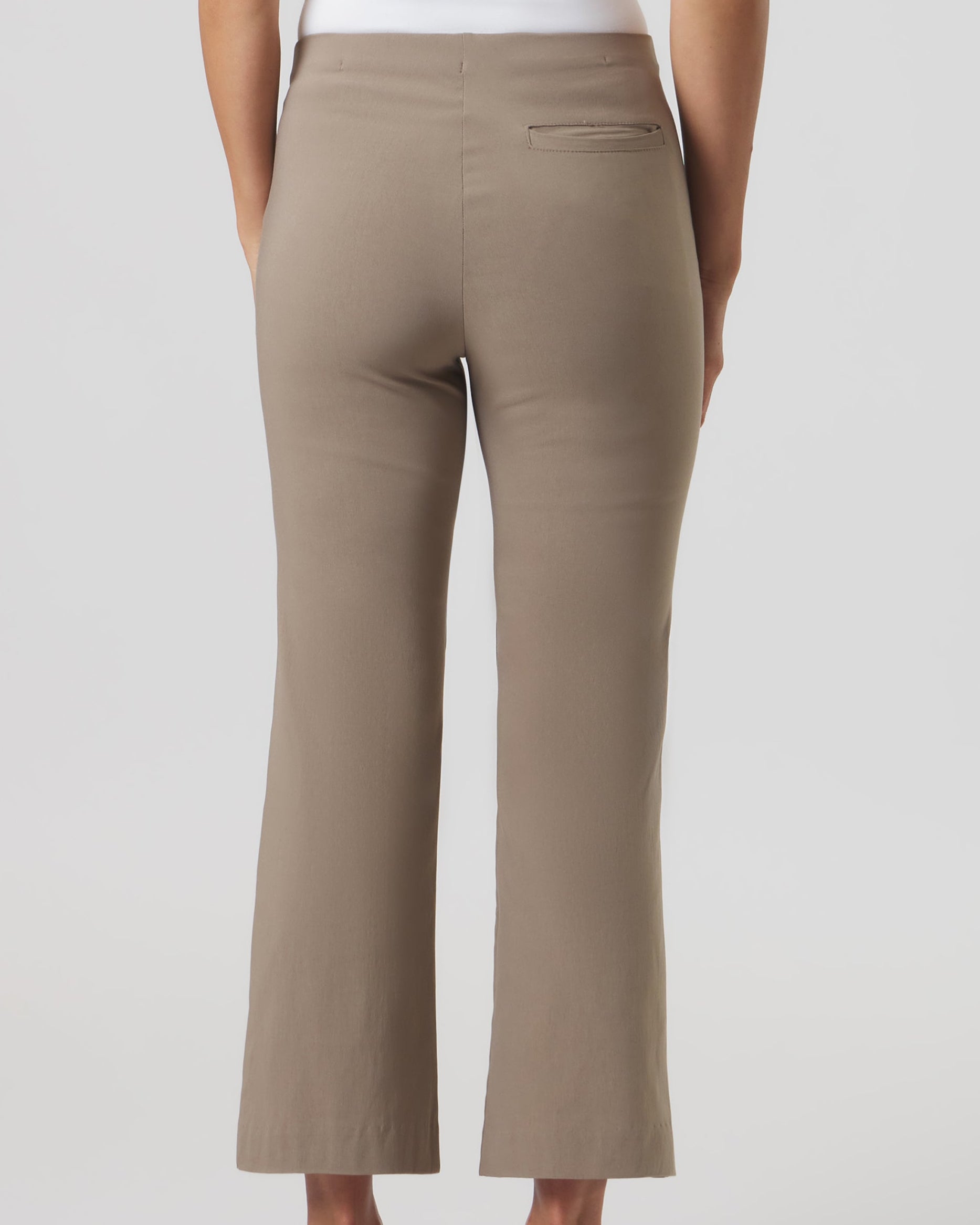 Beige pants worn by a person on a white background